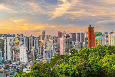 Modern buildings in city against sky during sunset