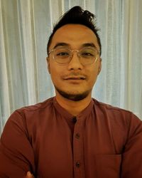 Portrait of young man standing at home