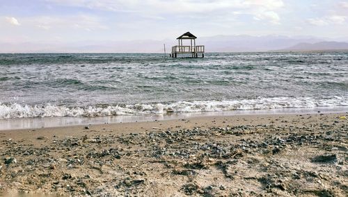 Lifeguard hut on beach against sky