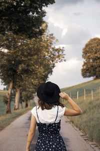 Rear view of woman photographing against sky