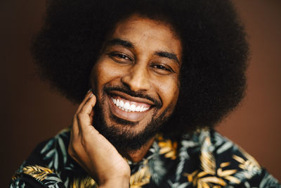 Portrait of happy man with hand on chin at studio