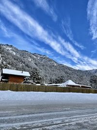 Houses on snow covered landscape against sky
