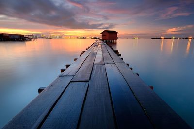 Pier over sea against sky during sunset