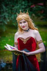 Young woman wearing crown standing outdoors