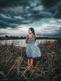 Woman standing on field against sky