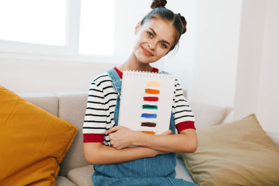 Young woman using digital tablet while lying on bed at home