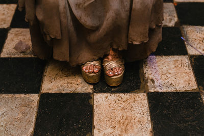 Low section of man standing on tiled floor