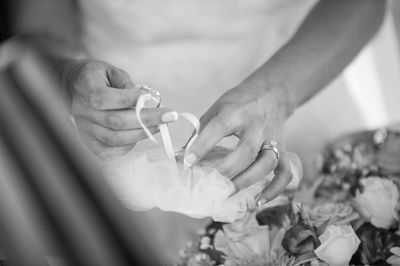 Midsection of bride taking wedding ring