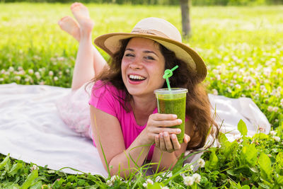 Portrait of a smiling young woman drinking water