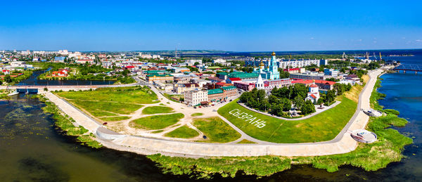 High angle view of buildings by sea against blue sky