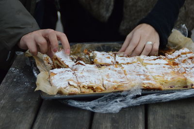 Close-up of hand holding bread on table