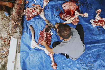 High angle view of butcher cutting beef