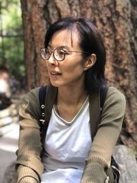 Portrait of mature man sitting on tree trunk