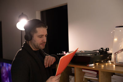 Man listening music on turntable at home