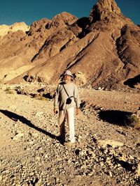 Full length of senior man walking on landscape against sky