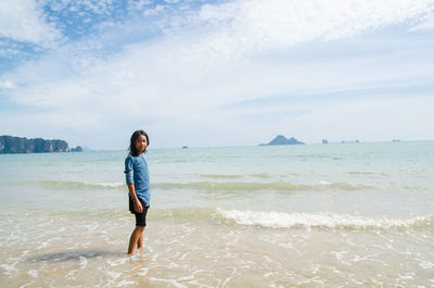 Full length of man standing on beach against sky