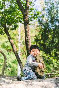 Portrait of young woman sitting on tree