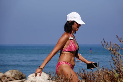 Woman on beach by sea against sky