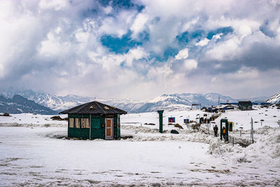 Houses on snowcapped mountain against sky