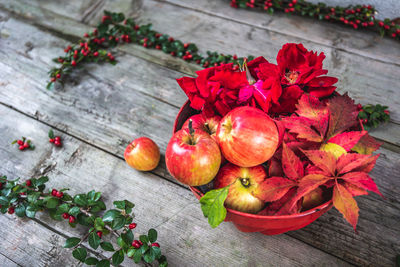 High angle view of red berries and apple on table