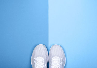 Low section of person standing against blue background