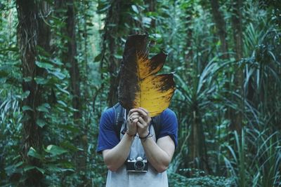 Man holding umbrella in forest