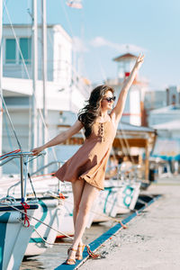 Young woman with arms raised in city