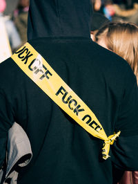 A person wearing caution tape during a protest. that reads fuck off.