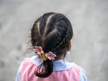 Rear view of woman with pink flower