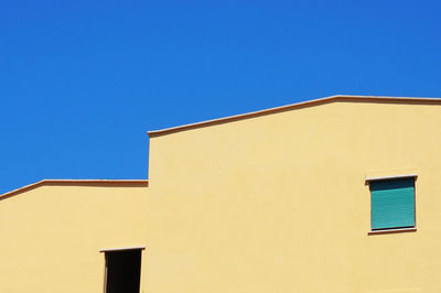 Low angle view of building against clear blue sky