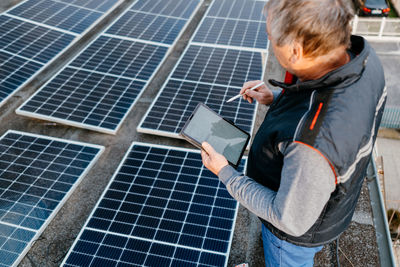 High angle view of engineer inspecting solar panel