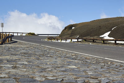 Surface level of road by city against sky