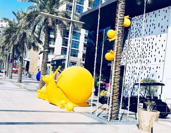 Yellow balloons and palm trees in city