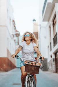 Portrait of young woman riding bicycle on street in city