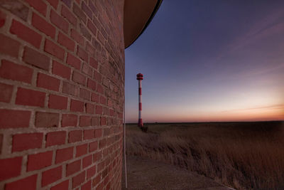 Red wall by building against sky