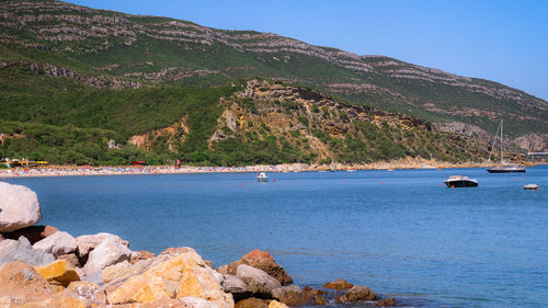 Scenic view of sea and mountains against sky