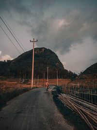 Road leading towards mountain against sky