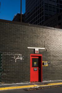 Red information sign on brick wall