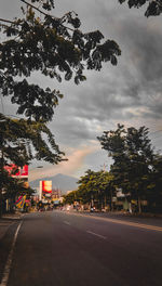 Road by trees against sky