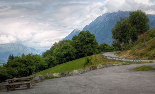 Road amidst trees against sky