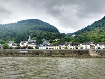 Scenic view of river with houses in background