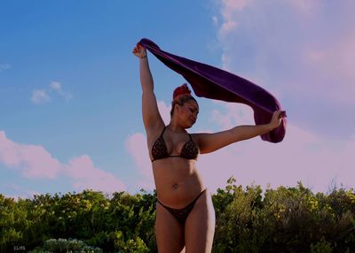 Full length of woman standing on plant against sky