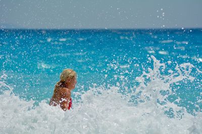 Rear view of man surfing in sea