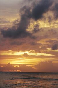 Scenic view of sea against dramatic sky during sunset