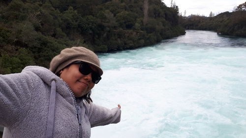 Smiling woman with arms outstretched at huka falls