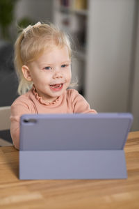 Portrait of cute baby boy sitting on sofa at home