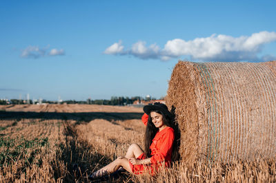 Rear view of woman standing on field against sky