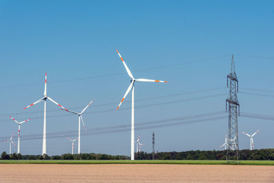 Overhead power lines and wind energy plants in the fields in germany