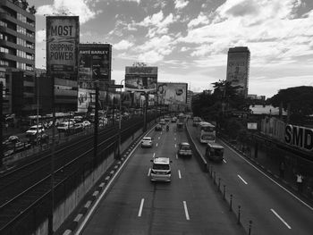 Vehicles on city street against sky