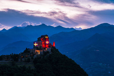 Scenic view of illuminated mountain against sky at dusk